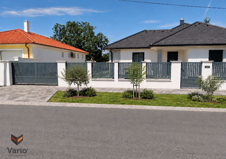 Függőleges elrendezésű 80x25mm-es alumínium kerítés elemeink, RAL7012-es színben, 20mm hézaggal az elemek között.